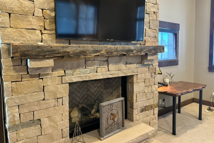 Beam fireplace mantle on stone hearth